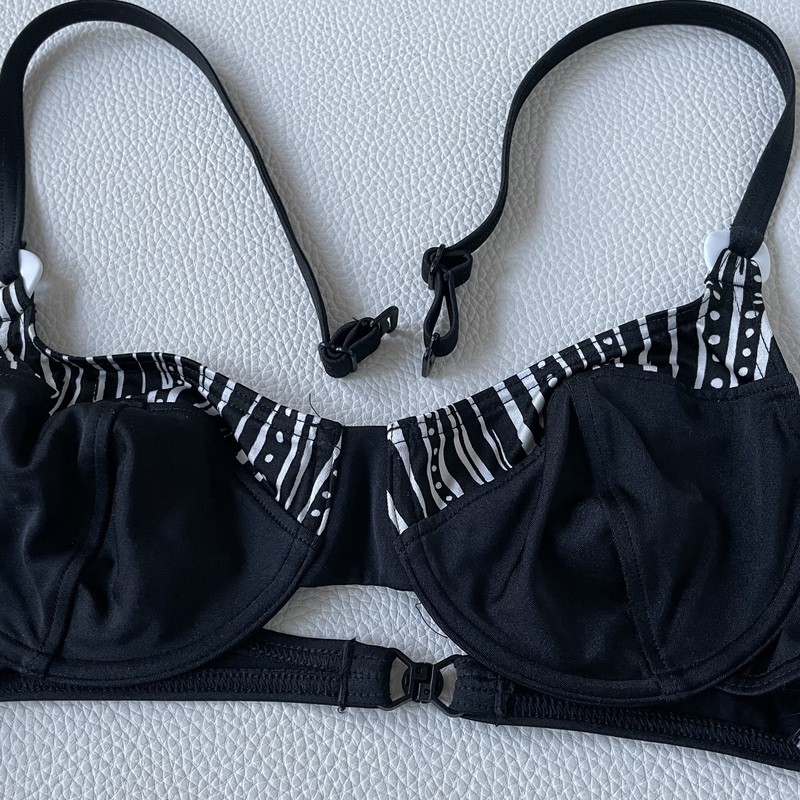 Mustavalkoinen bikini-yläosa. Kaarituettu.
Triumph Lillyets, koko 38  B